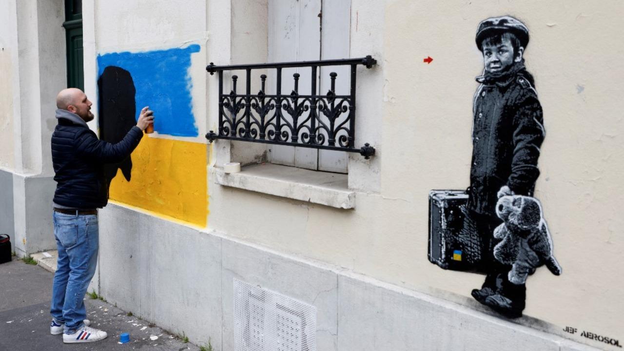 French street arist Kelu Abstract creates a street art painting dedicated to the Ukrainian people after the Russian invasion of Ukraine, in Paris, on March 4, 2022. Photo: AFP